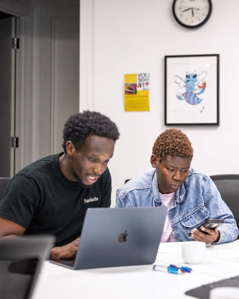 A Sankofa facilitator and a participant working together at a laptop